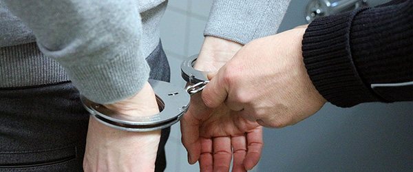 Hands behind back wearing handcuffs